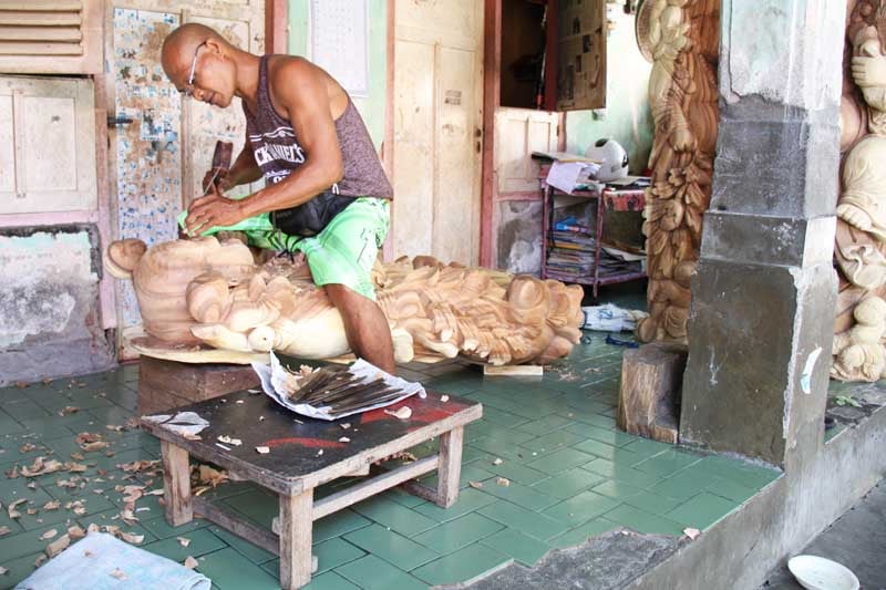 Mr Will carving a large wooden fat Buddha statue.